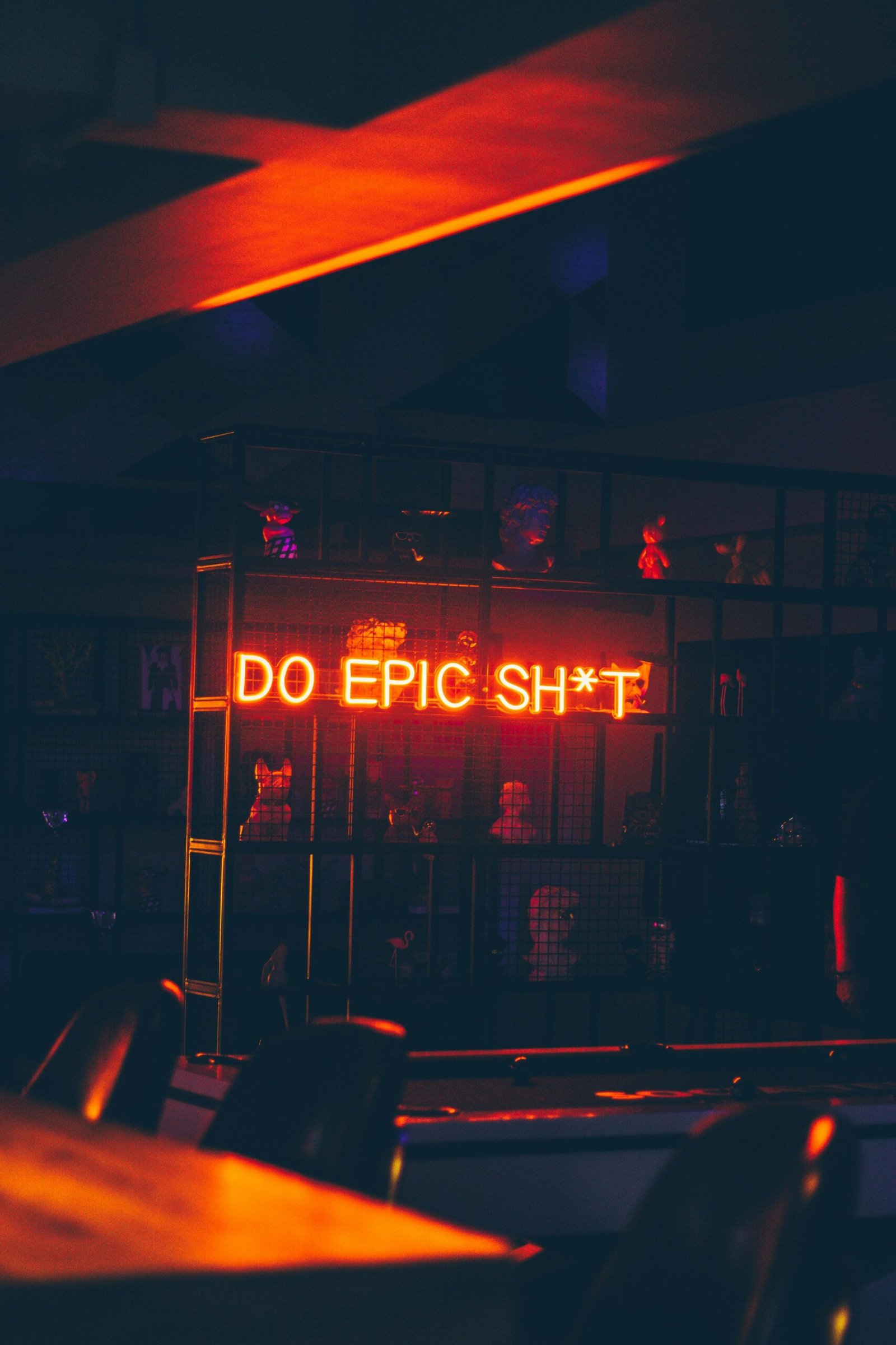 Moody bar interior with neon text 'Do Epic Sh*t' creating a bold atmosphere.